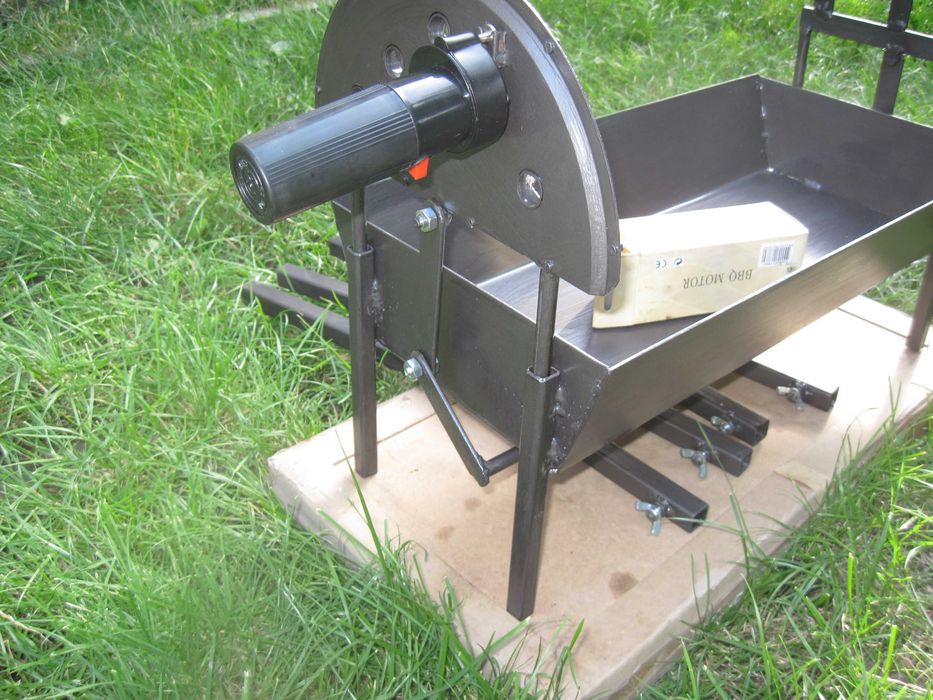 Барбекю на дървени въглища с въртящи се шишове и скара.