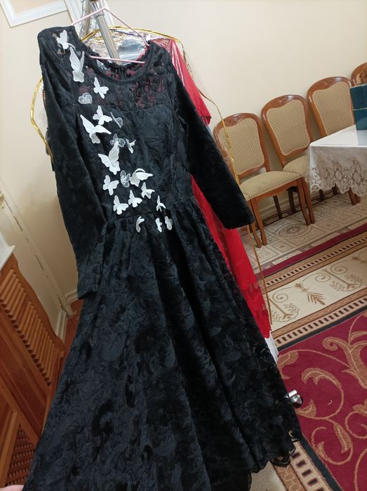 Qora ko'ylak oldi qismiga kapalekla bilan ishlov berilgan