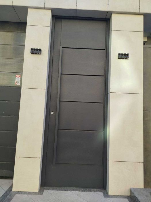 Входные двери в едином стиле с секционными воротами.