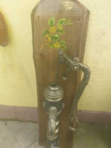 Fantana arteziana din fonta asezata pe un suport de lemn pictata