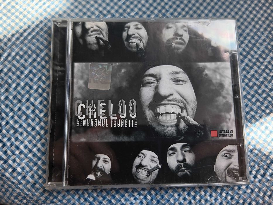 CD Cheloo, intitulat „Sindromul Tourette”, lansat în 2003 prin casa de discuri Rebel Music, Muzica Hip Hop Romanesc