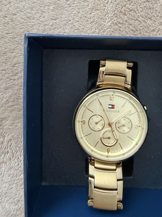 Стилен дамски часовник Tommy Hilfiger в златист цвят. Много запазен, с оригинална кутия. Подходящ за ежедневие и официални поводи.