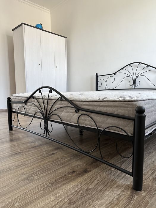 Металлическая кровать с матрасом.