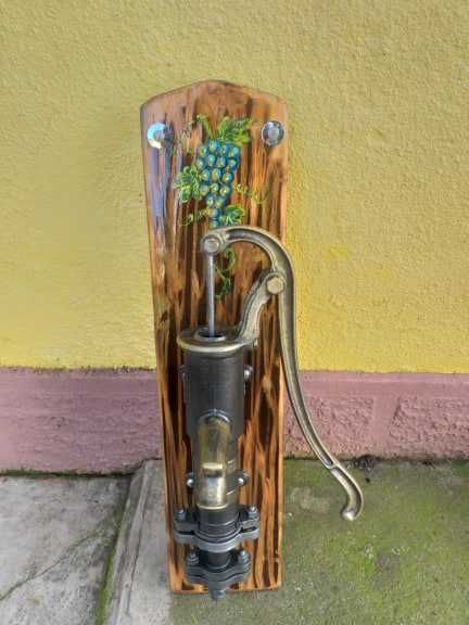 Fantana vintage din fonta asezata pe un suport de lemn