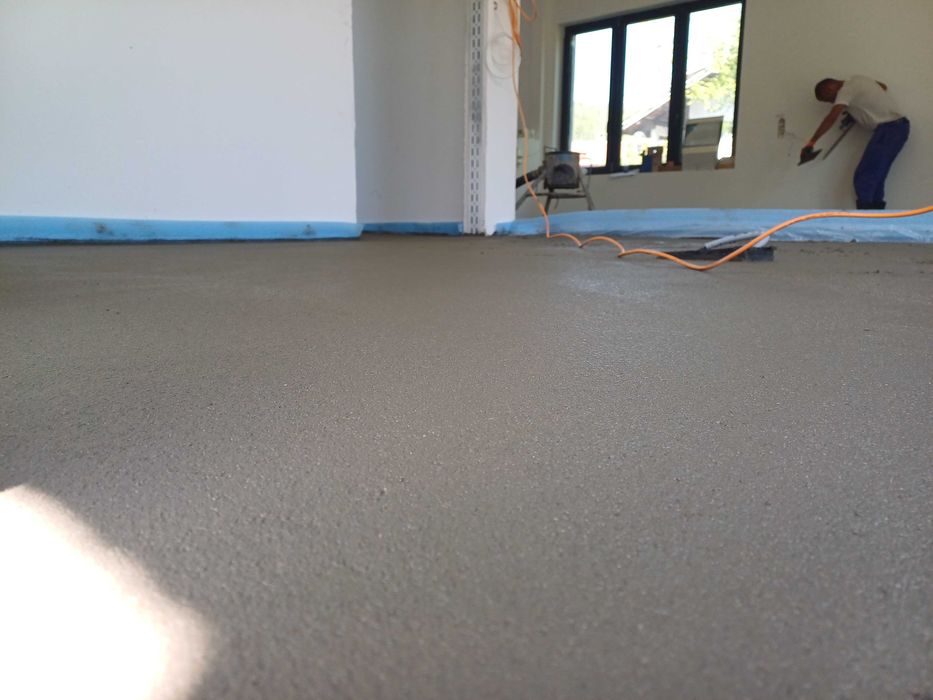 Полагане на машинна циментова замазка.