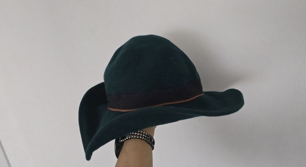 Зимна вълнена тъмно зелена дамска шапка.