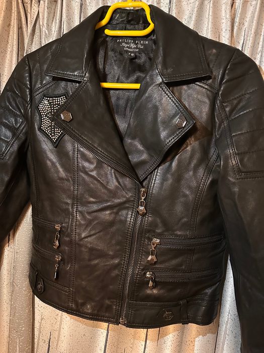 Vand geaca de dama neagra Philipp Plein, cu desing elegant, croiala biker, fermoar asimetric. Geaca este intr-o stare foarte buna.