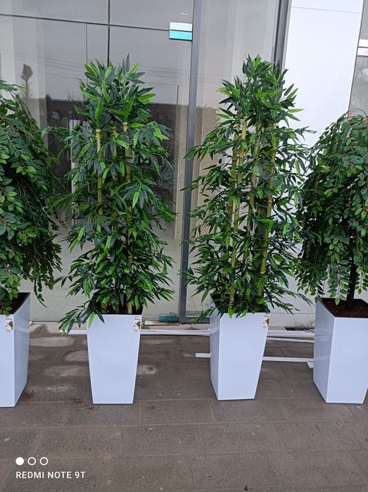 Перечисленные искусственный цветы и деревья