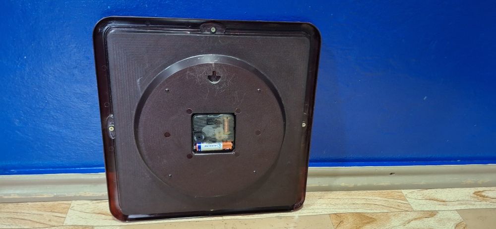 Настенные часы с коричневой окантовкой.