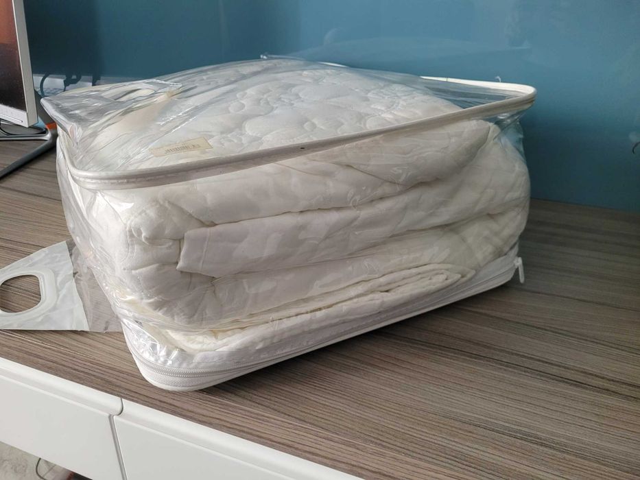 set de cuvertură de pat albă, matlasată, disponibil de obicei în seturi de 3 piese (o cuvertură și două fețe de pernă).