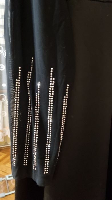 Рокля с мрежест детайл на деколтето и ръкавите, гарниран с камъчета.