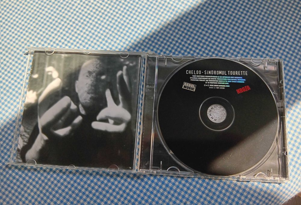 CD Cheloo, intitulat „Sindromul Tourette”, lansat în 2003 prin casa de discuri Rebel Music, Muzica Hip Hop Romanesc