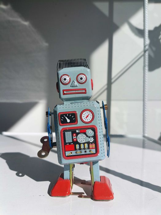 Робот, тенекиена играчка, навива се с ключ и се движи.