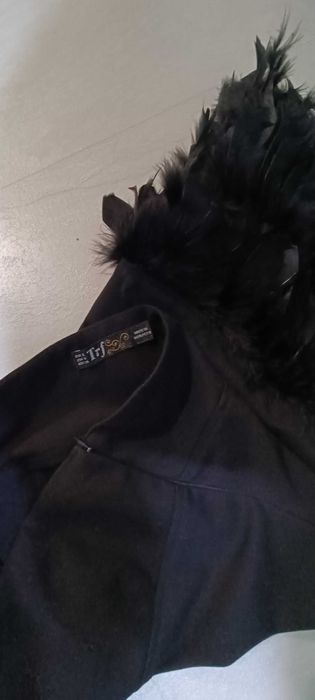 Малка черна рокля с естествени пера в долната част.