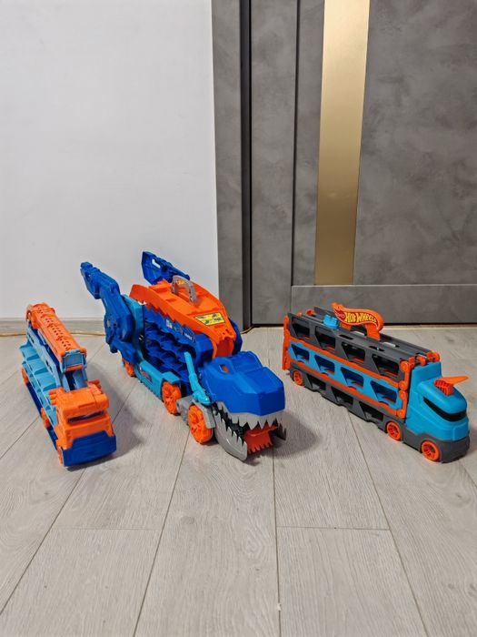 Mega Lot Hot Wheels: Ultimate Garage T-Rex, Piste, 14 Monster Trucks + 220 Mașinuțe
