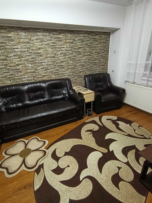 Vand coltar extensibil impreuna cu un fotoliu din piele neagra.