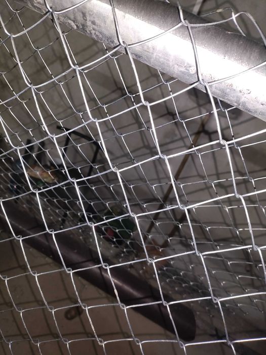 Плетене на оградна мрежа от поцинкована тел .