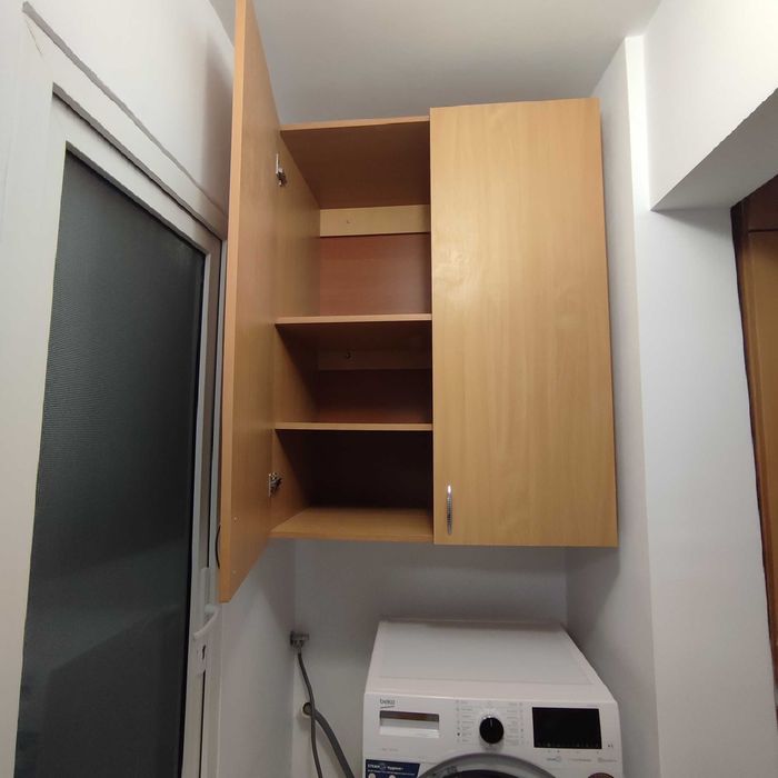 Dulap suspendat deasupra mașini de spălat.