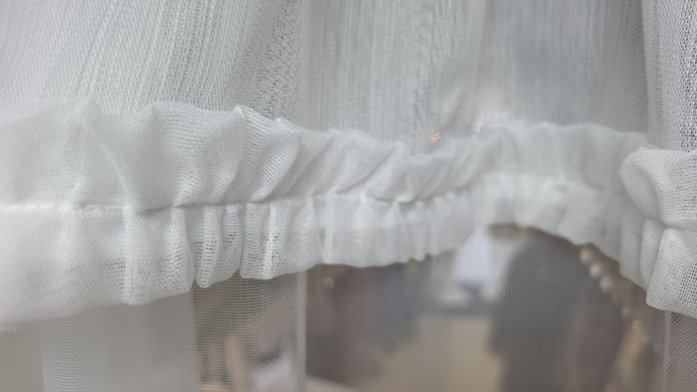 o perdea albă gata confecționată, în stil clasic/romantic, potrivită de regulă pentru bucătării, balcoane sau ferestre de dimensiuni medii și mici.