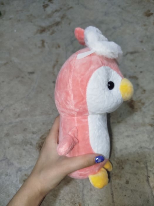 МягкаЯ плюшевая игрушка в виде циплёнка с маской на голове.