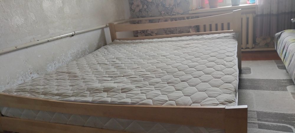 деревянная кровать с матрасом.