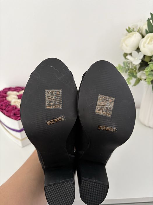Vand botine negre din piele întoarsă au un design perforat și un vârf deschis.