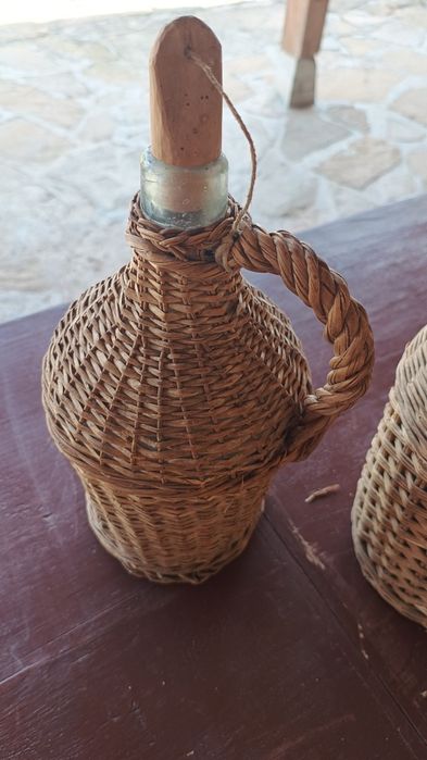 Продавам два броя стъклени дамаджани външно плетени от естествени материали