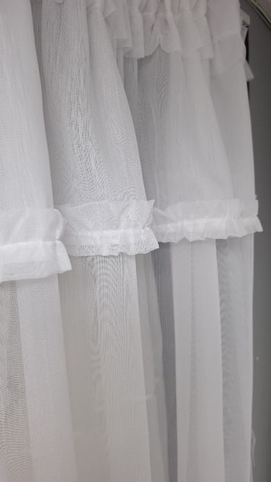 o perdea albă gata confecționată, în stil clasic/romantic, potrivită de regulă pentru bucătării, balcoane sau ferestre de dimensiuni medii și mici.