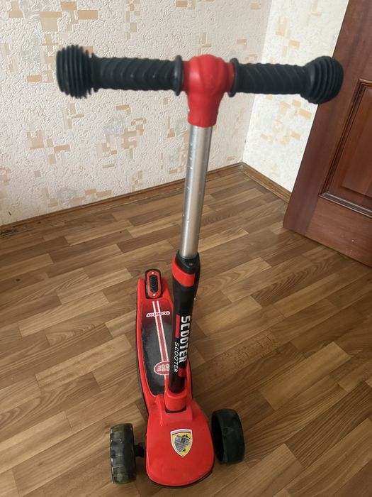 Детский самокат красного цвета