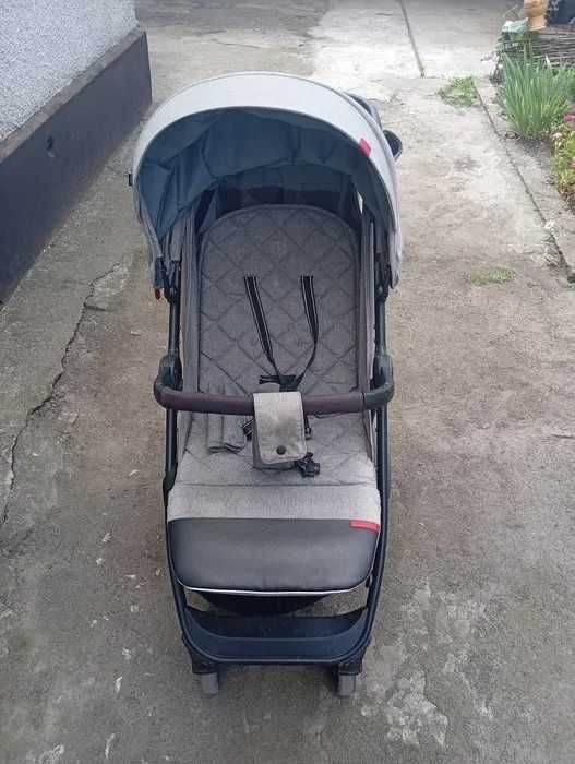 Un cărucior de vară/iarnă din Garniy Stan, o tablă de culoare gri și o husă de iarnă