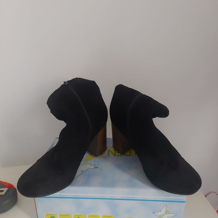 Vind o pereche de botine cu fermoare în interior.