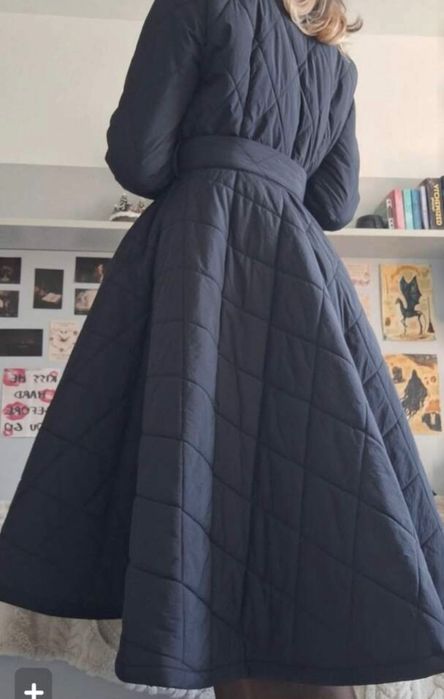 Дълго ватирано палто в класически черен цвят.