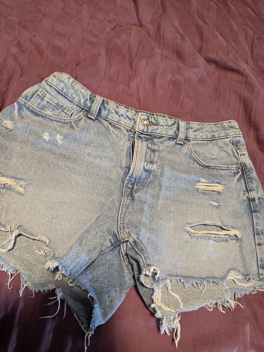 Vând shorts din denim bleu deschis, model super rupt/distressed