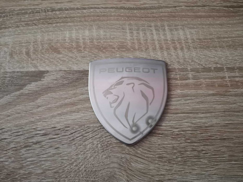 бяла метална емблема Peugeot с новото лого
