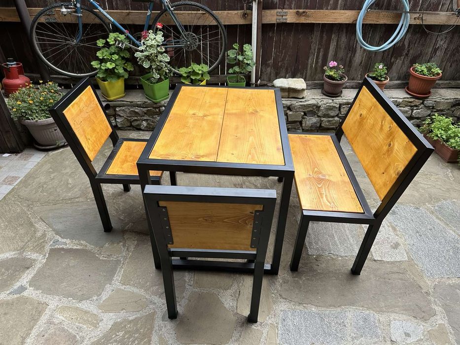 Градиндка маса с пейка и столове от дърво и метал.