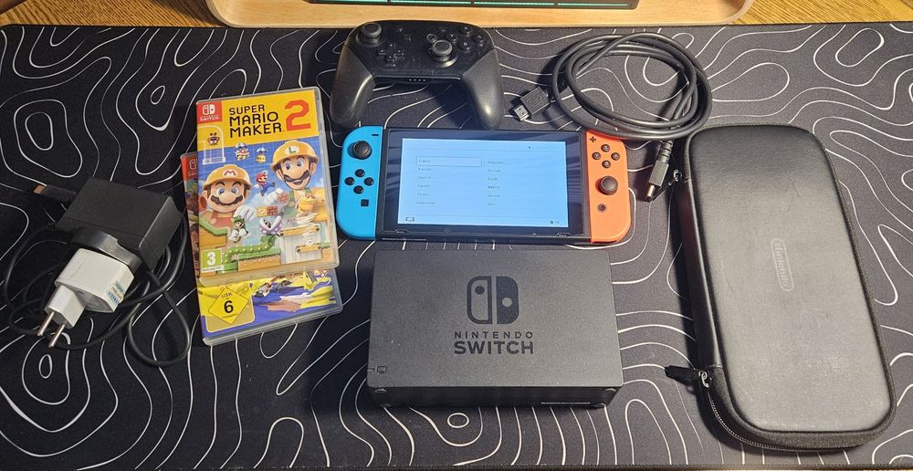 Nintendo Switch (modelul "red box") + accesorii (Pro Controller și husă) + jocuri (Mario Maker 2 și Splatoon 3)