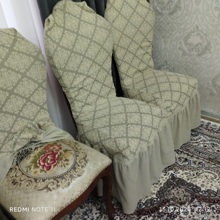 Стол мебельный и восемь стульев с чехлами.