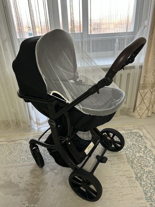 Продаётся современная детская коляска в чёрном цвете.