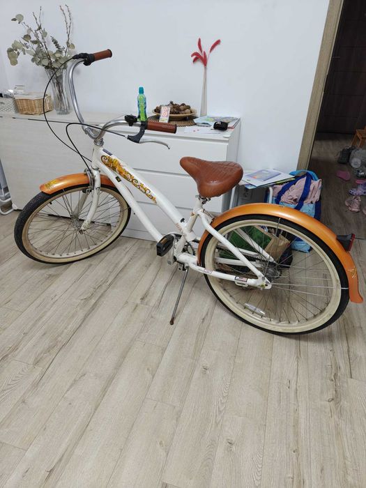 Bicicletă Nirve Cruiser, model retro/vintage, cu un design deosebit alb-portocaliu.