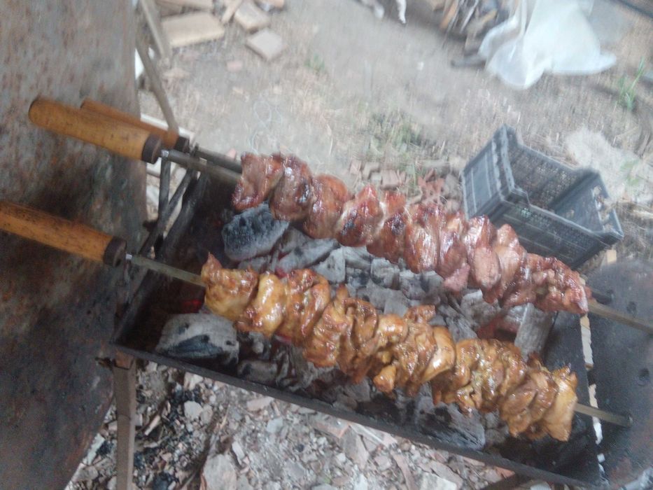 Барбекю на дървени въглища с въртящи се шишове и скара.