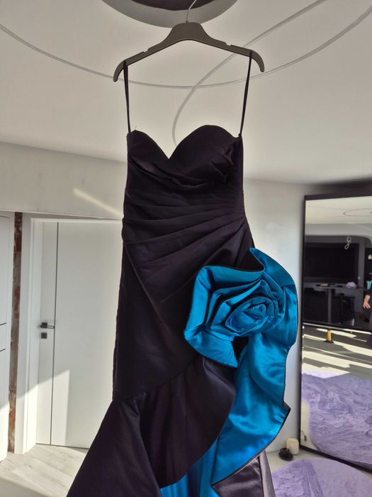 Официална дизайнерска рокля с висока цепка и син акцент.