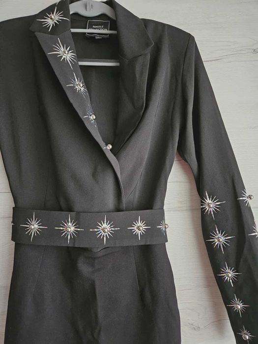 Елегантна черна рокля с декоративни елементи.