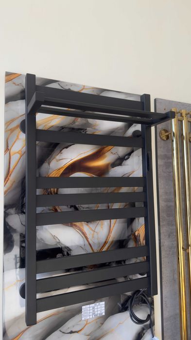 Полотенцесушитель с полочкой от производителя черного цвета.