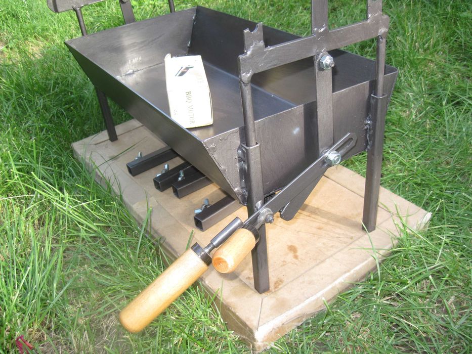 Барбекю на дървени въглища с въртящи се шишове и скара.