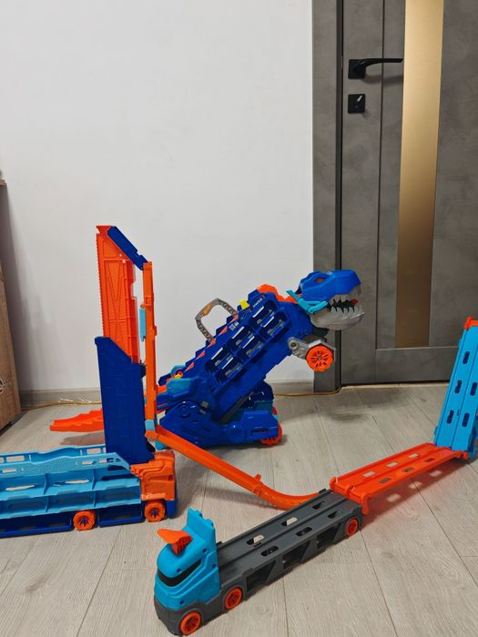 Mega Lot Hot Wheels: Ultimate Garage T-Rex, Piste, 14 Monster Trucks + 220 Mașinuțe