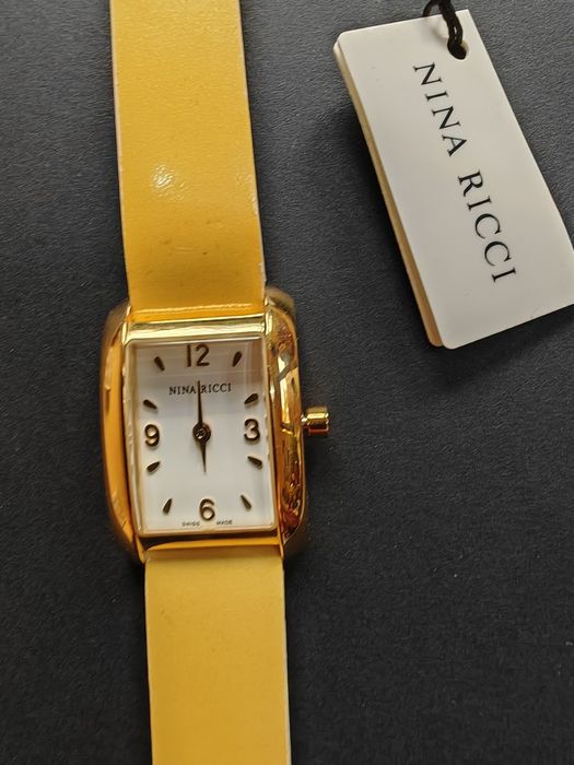 Ceas de dama Nina Ricci  auriu cu cadran alb original, nou  fără cutie