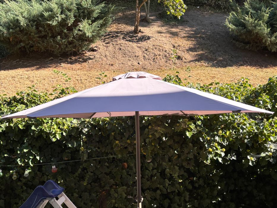 Umbrelă de terasă de la JYSK, cu suport greu inclus.