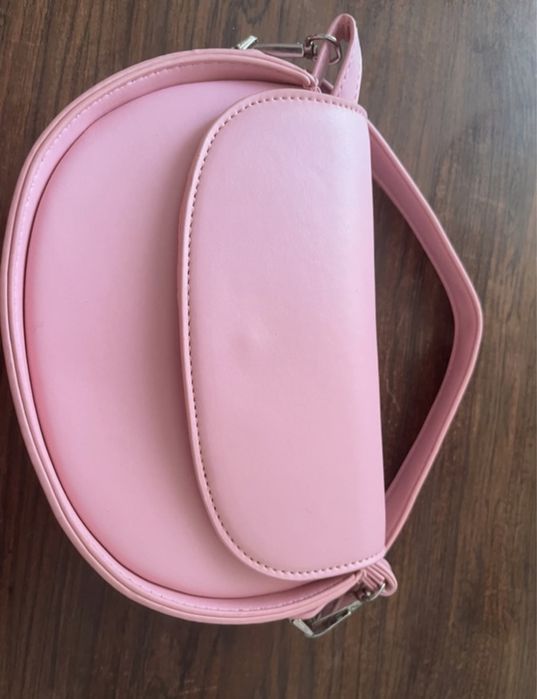 Geanta mica de culoare roz, cu bareta de maine si de umar.