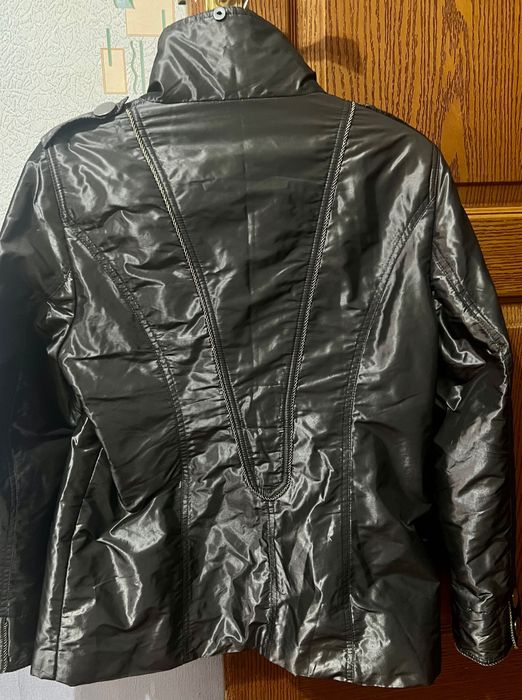 Куртка-сафари с четырьмя карманами и металлическими пуговицами.