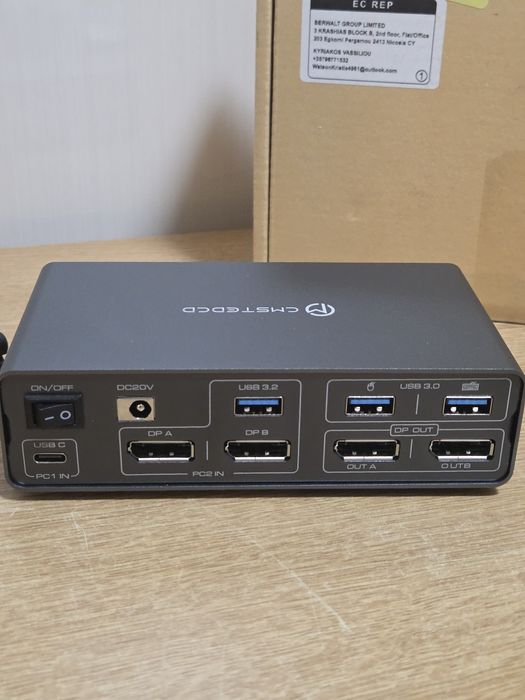 KVM докинг станция (модел CMSTEDCD SW523P), която позволява споделянето на монитори и периферия между два компютъра.